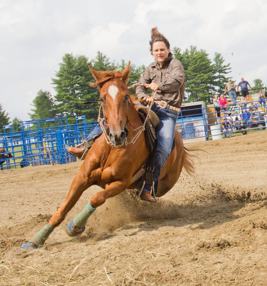 Barrel racing saddle in competition — deep secure seat, high horn for turn support